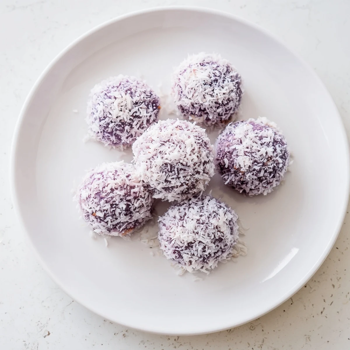 Golden Coconut Ube Besito cookies cooling on a wire rack with purple speckles visible