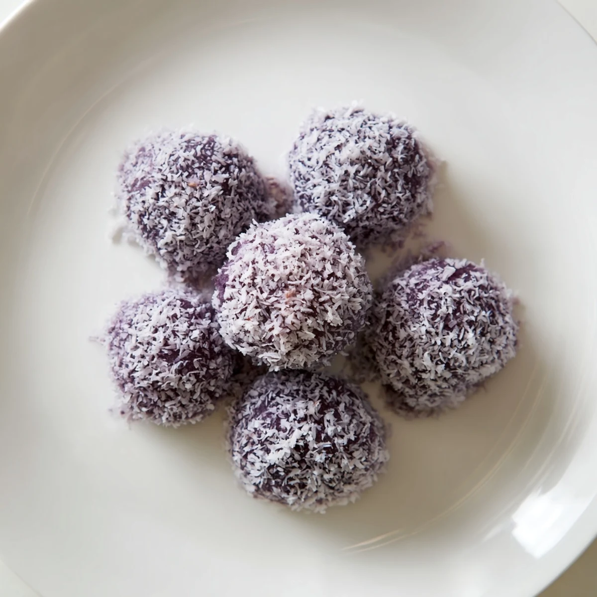 Bite-sized Coconut Ube Besito cookies baked until golden with shredded coconut throughout