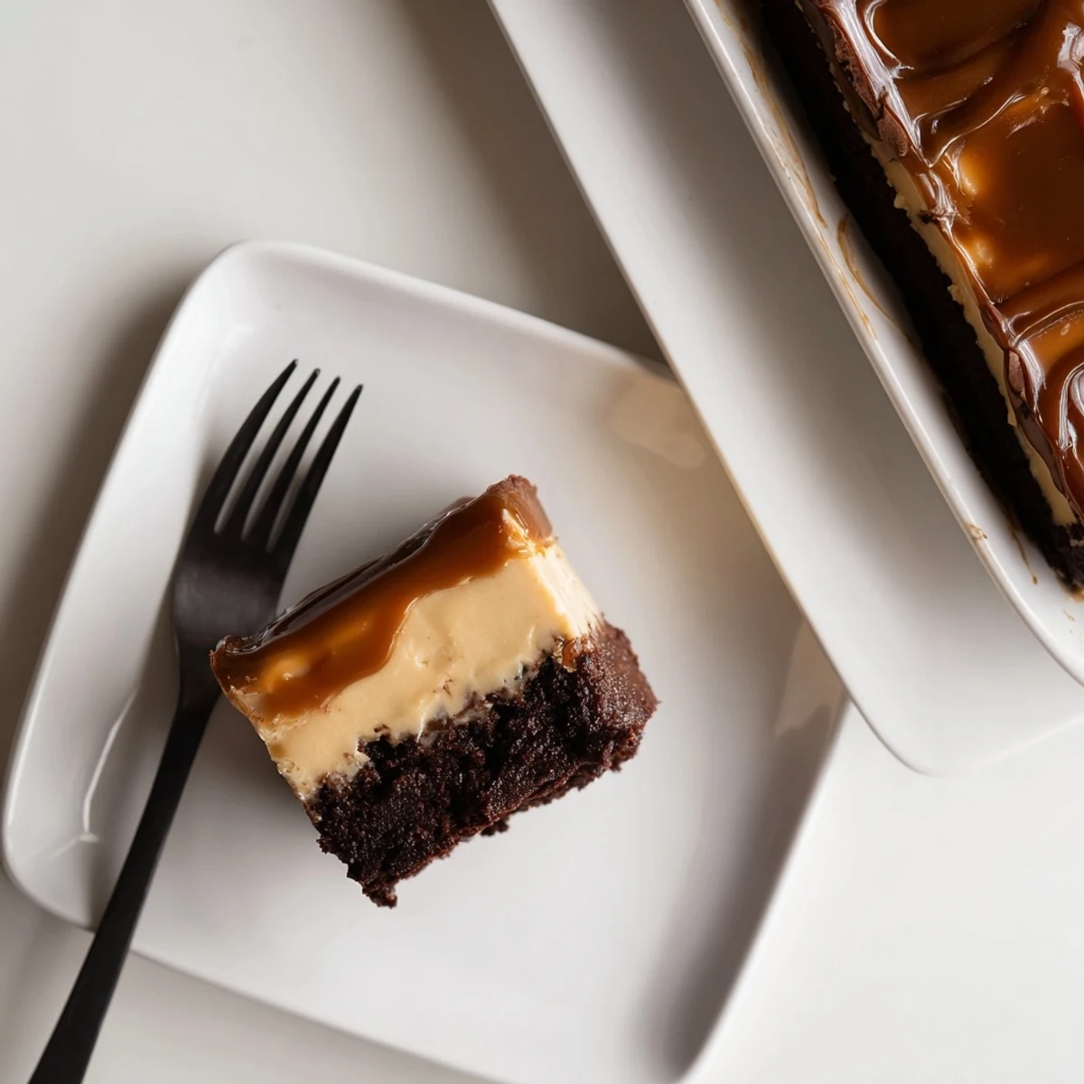 Rich caramel brownie cheesecake bars with fudgy chocolate base and golden drizzle
