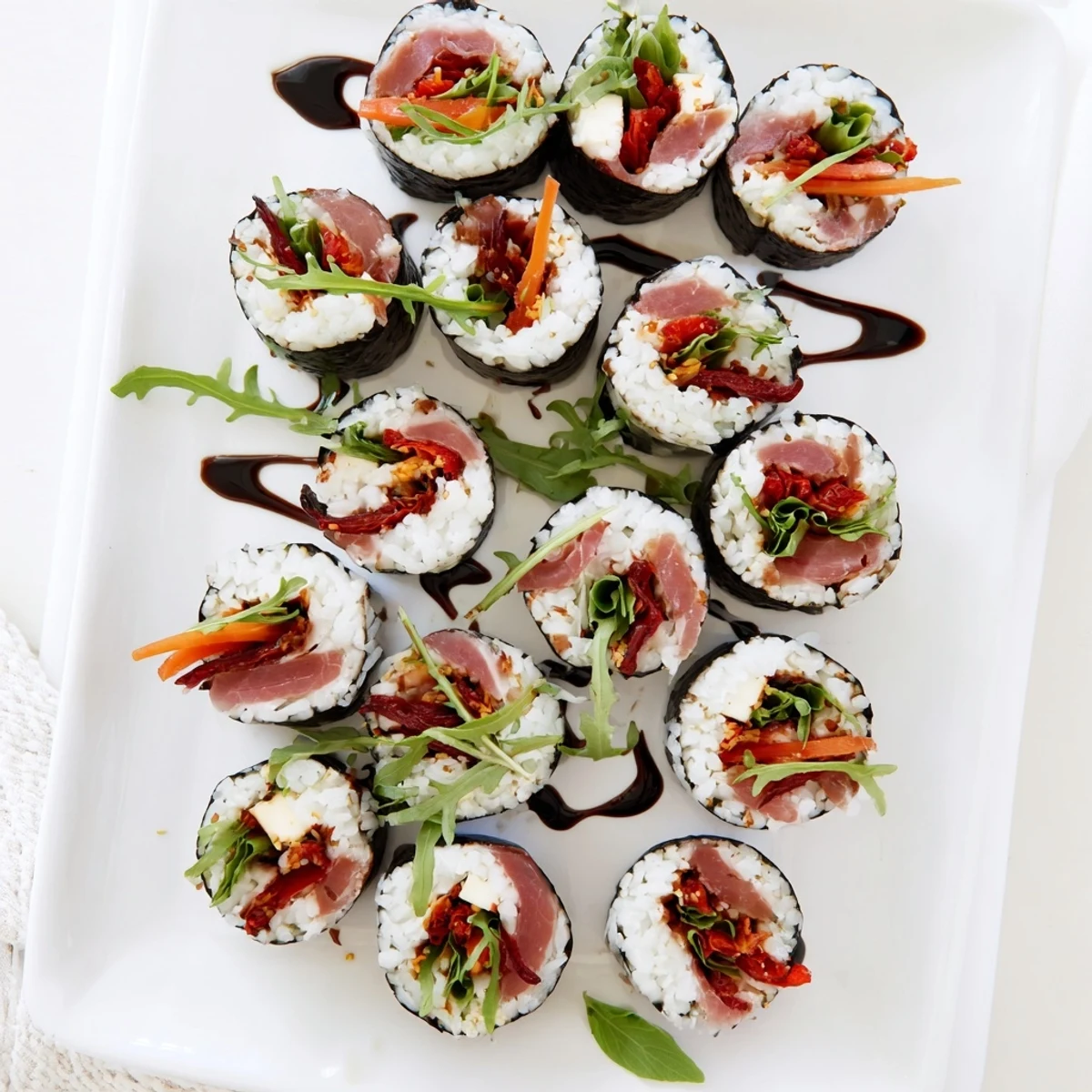Fusion sushi platter featuring Italian ingredients like sun-dried tomatoes and arugula arranged elegantly