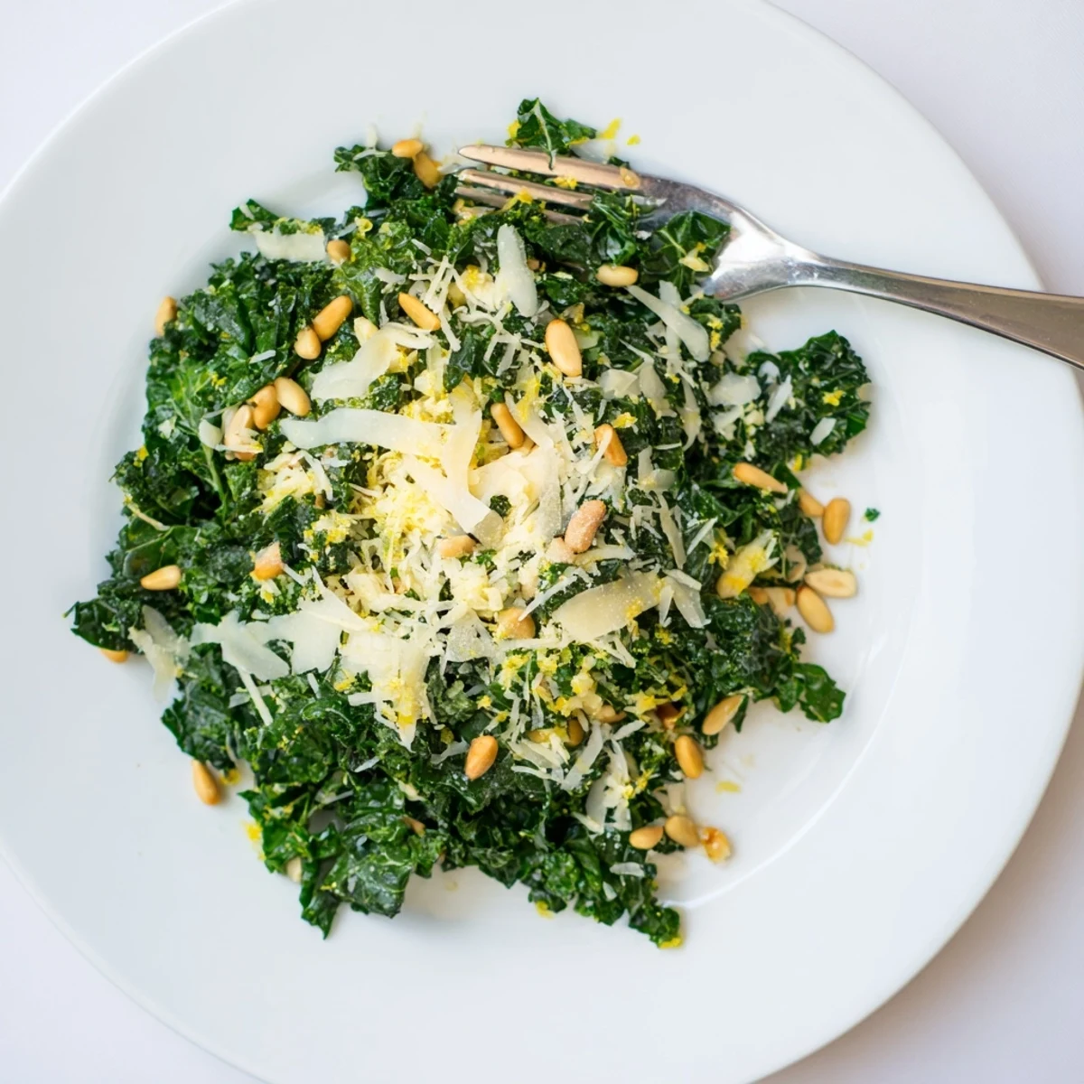 Massaged kale leaves glistening with zesty garlic lemon Parmesan dressing close up