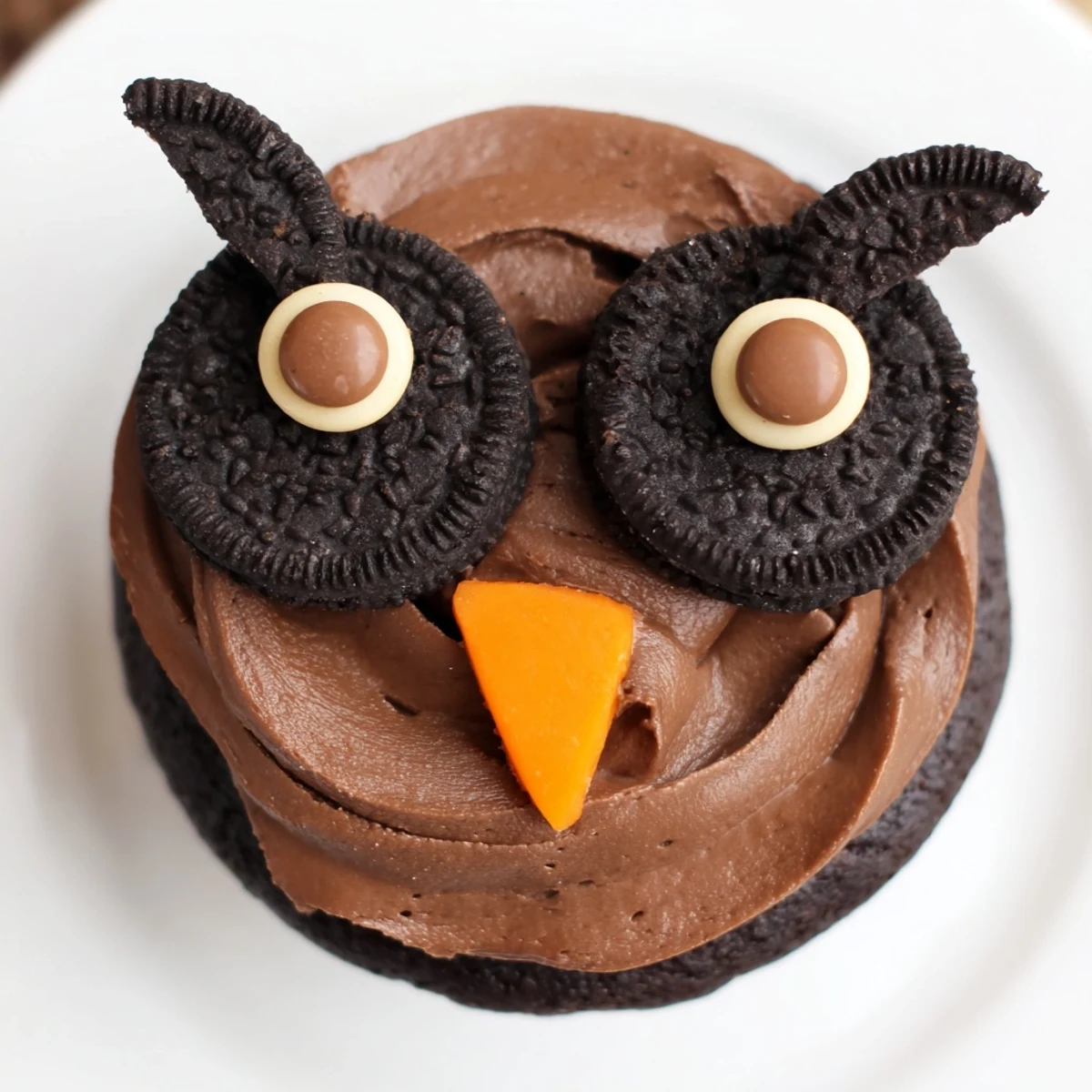 Oreo Owl Cupcakes with chocolate frosting and candy eyes on a rustic serving tray
