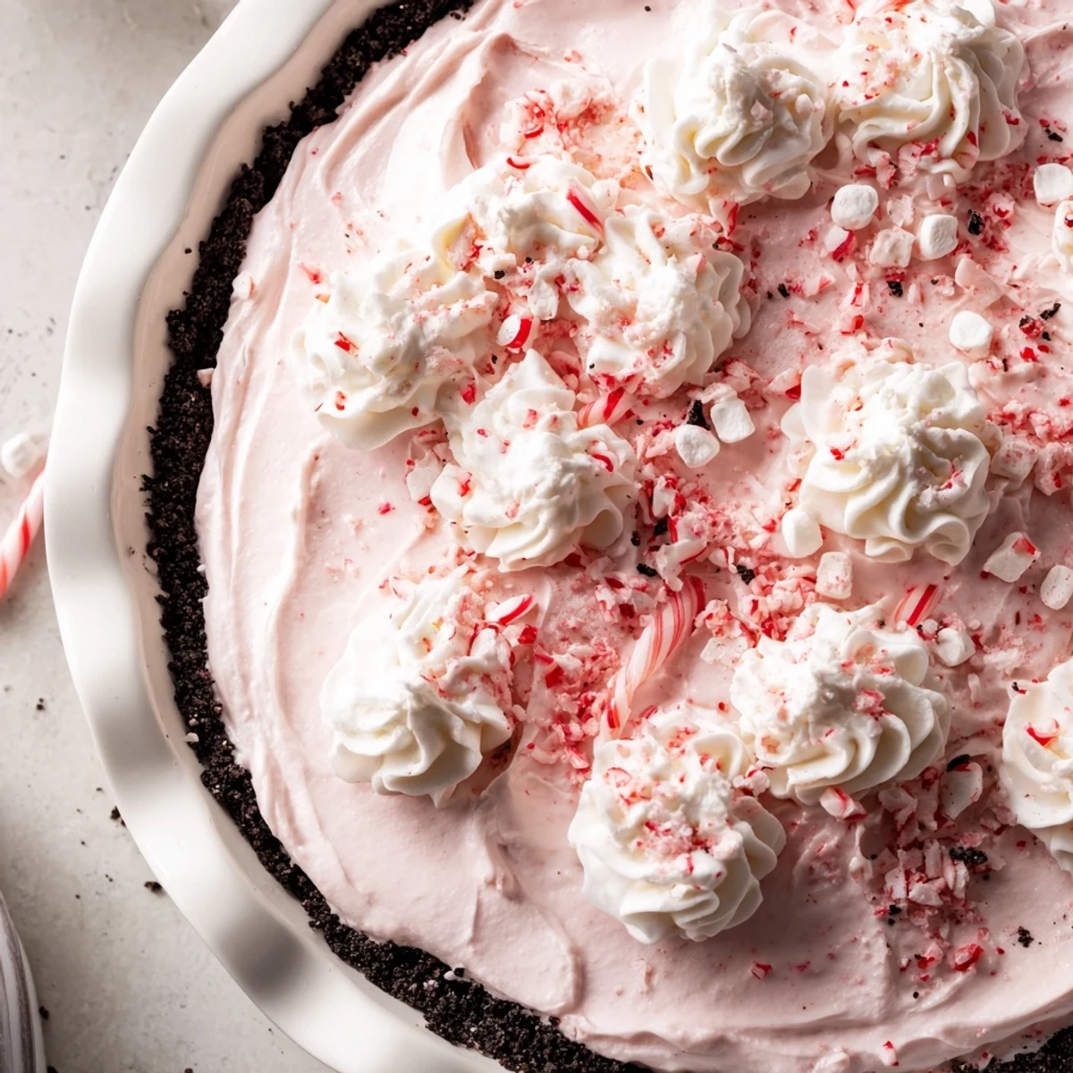 Slice of Candy Cane Pie resting on plate, fluffy whipped cream dollop