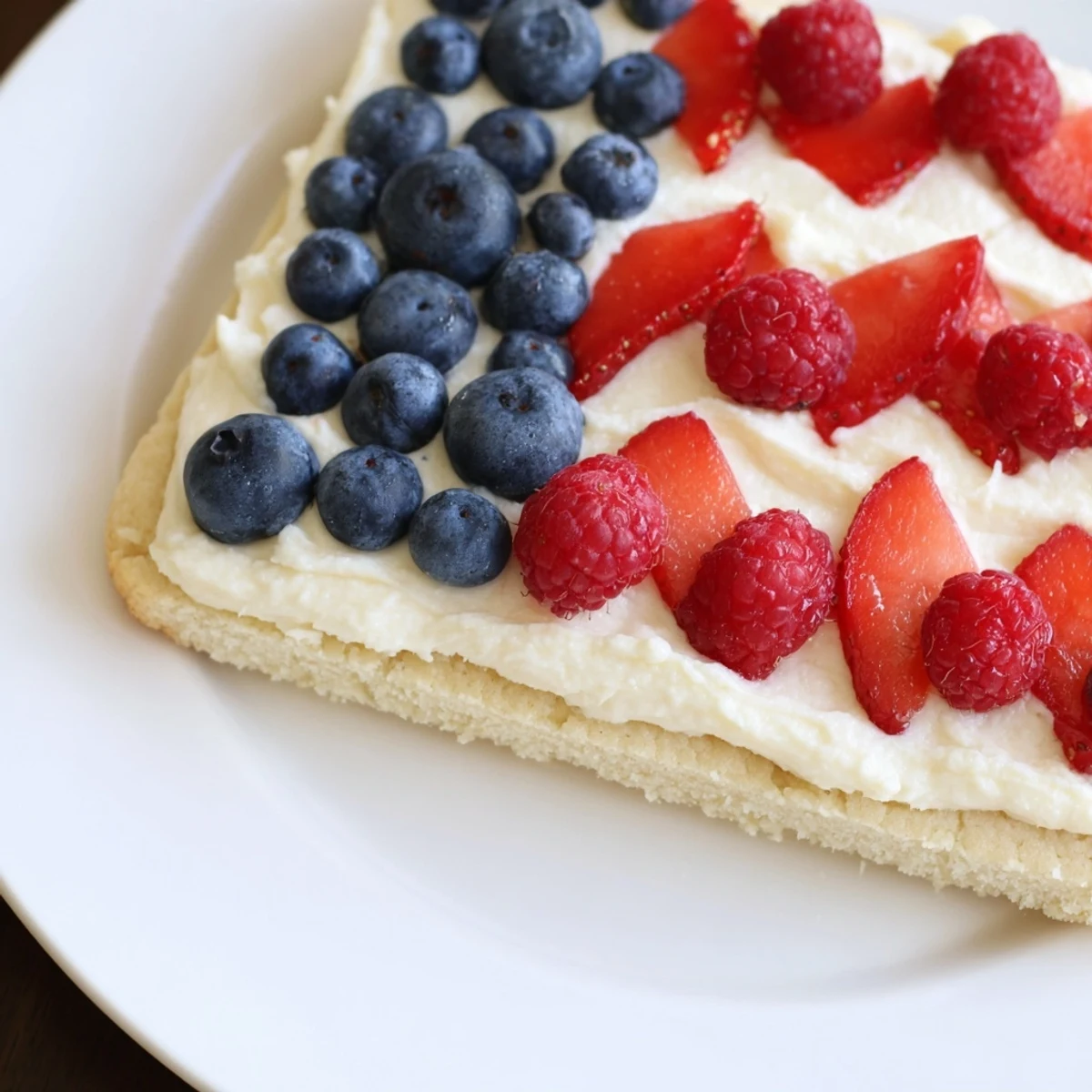 Chilled Sugar Cookie Flag Fruit Pizza sliced for summer picnics, bright berries