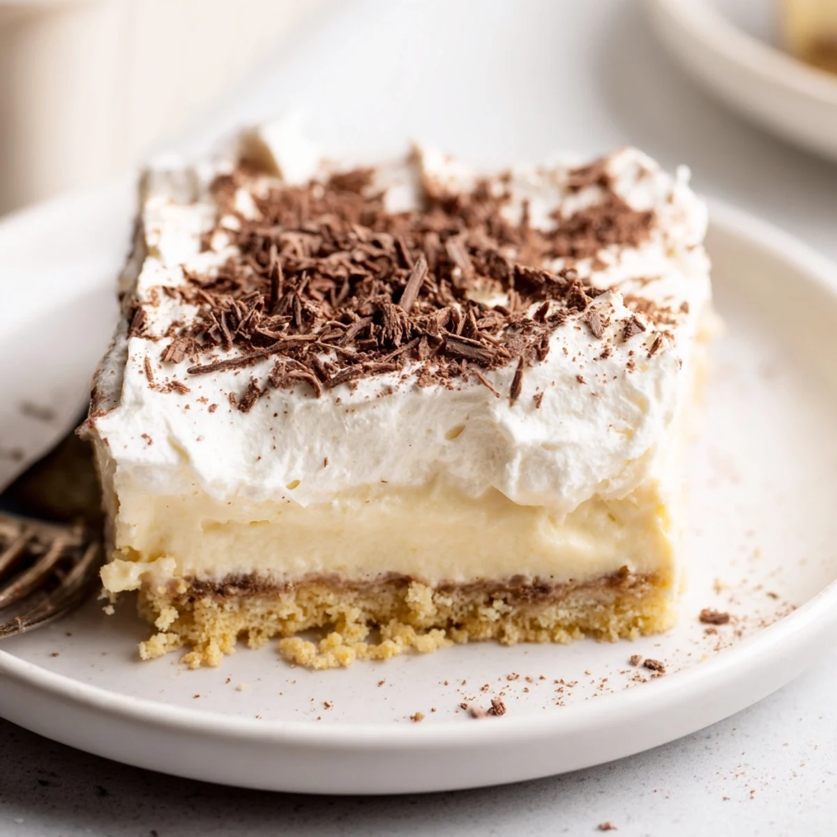 Slices of No Bake Layered Dessert topped with chocolate shavings, ready to serve