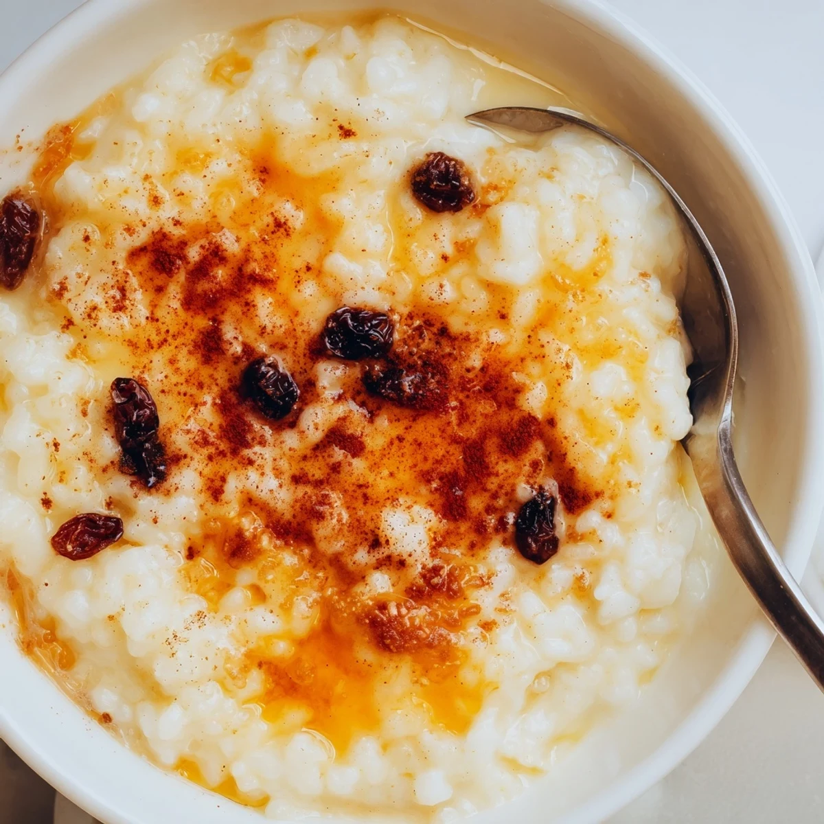 Creamy Delicious Condensed Milk Baked Rice Pudding cooling in buttered ceramic dish.