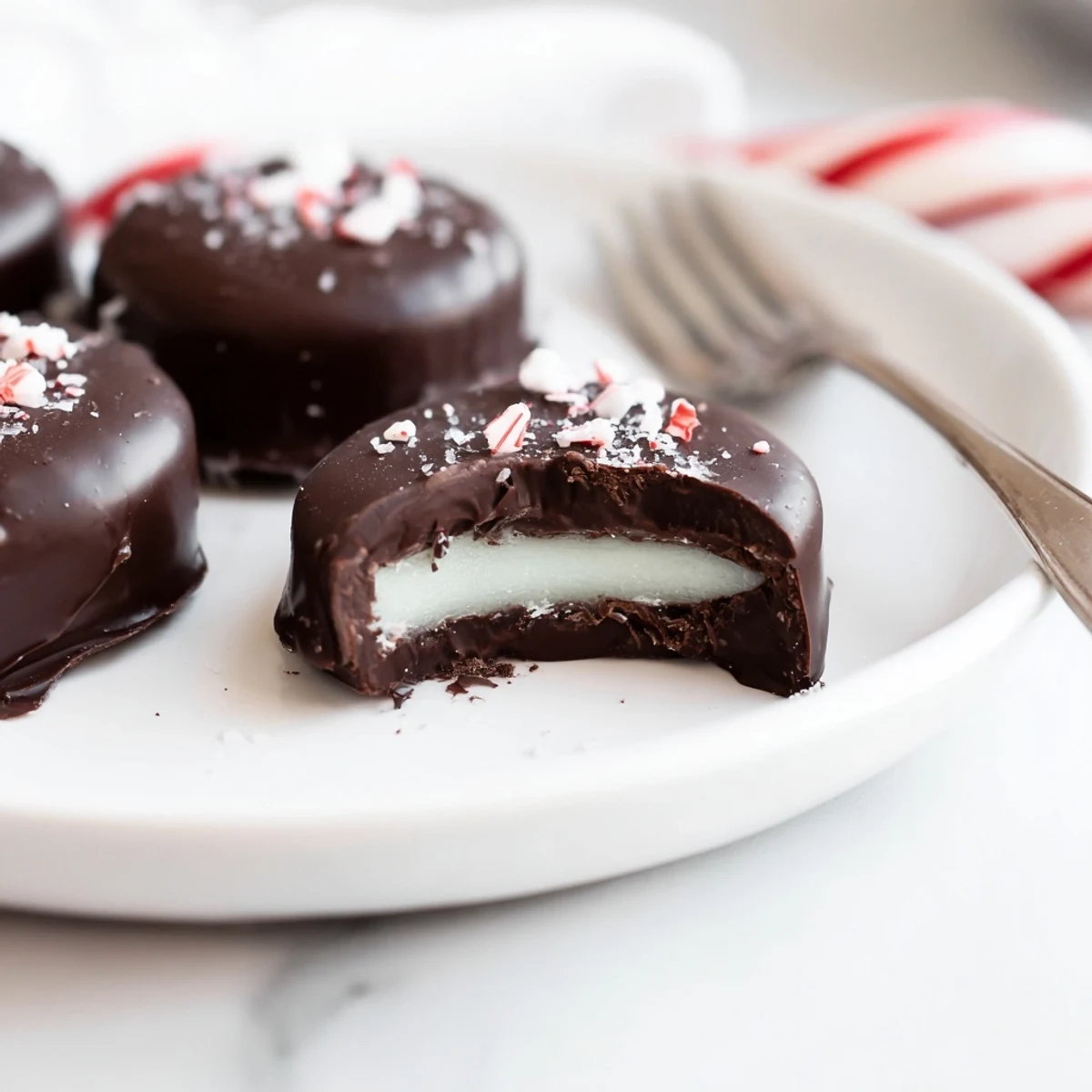 Stacked Peppermint Patties beside coffee, smooth dark coating, cool creamy center