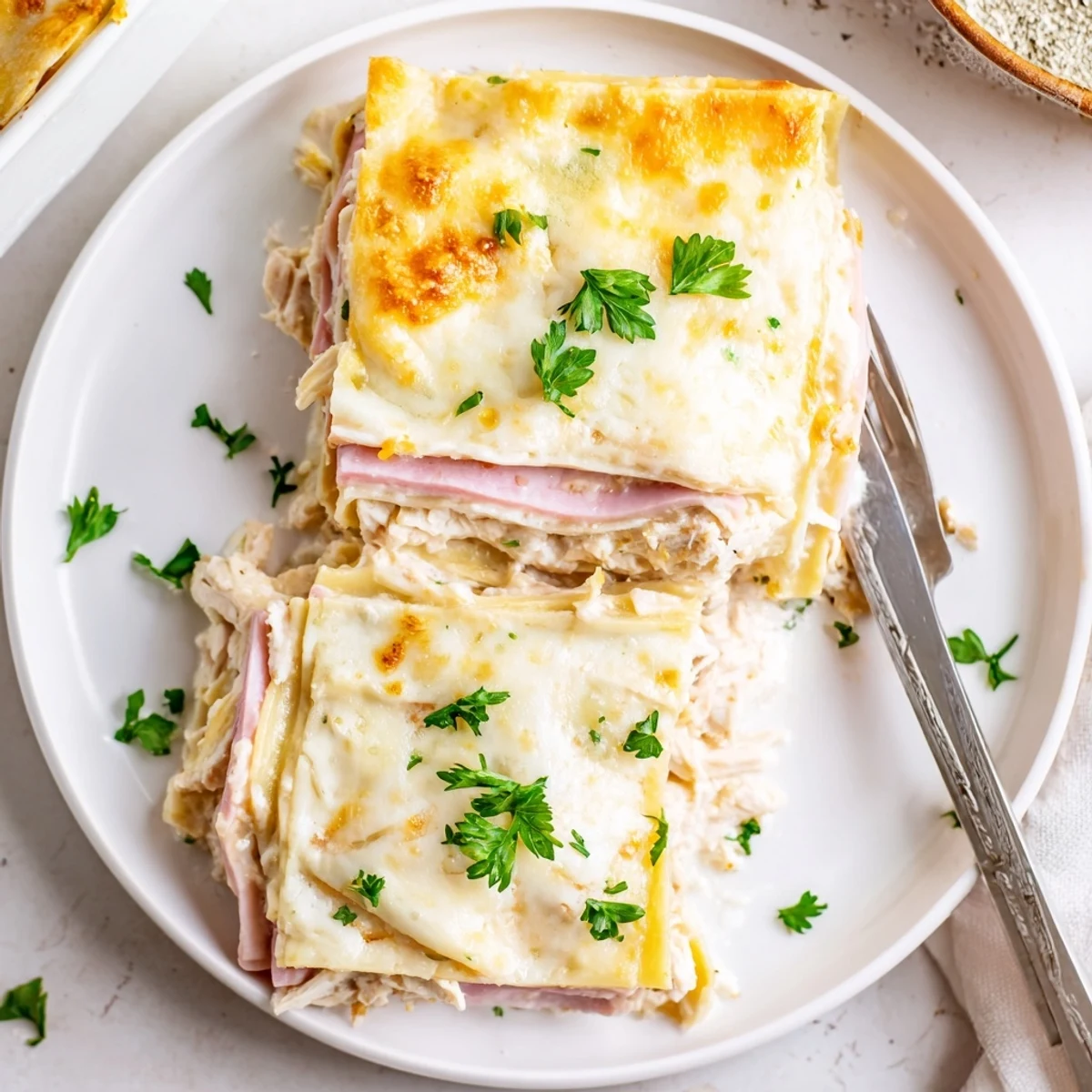 Layered chicken cordon bleu lasagna featuring tender pasta sheets with ham and melted mozzarella topping