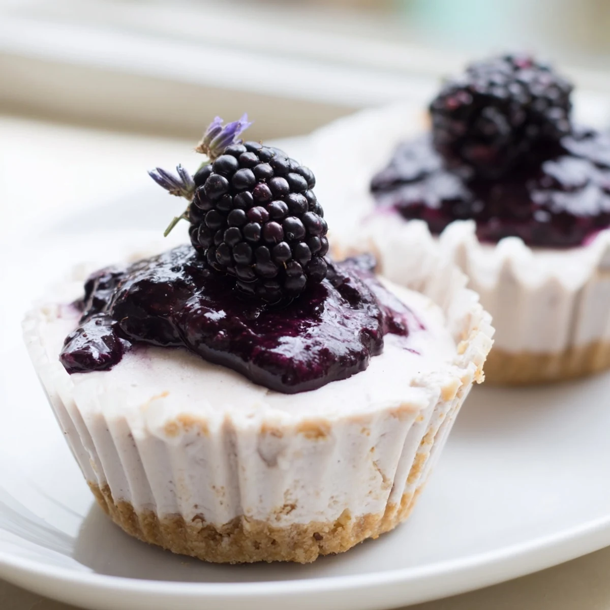 Creamy no bake mini blackberry lavender cheesecakes topped with glossy purple berry sauce
