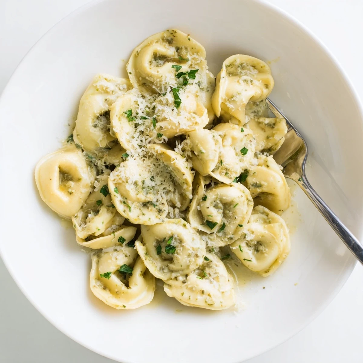 Golden homemade chicken tortellini tossed in a rich parmesan cream sauce and garnished with fresh parsley.