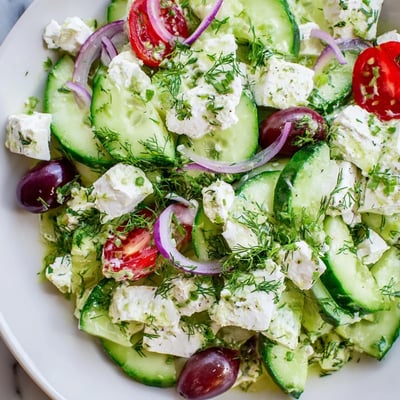 Creamy feta cucumber herb salad topped with fresh dill and mint