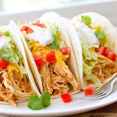 Slow cooker ranch chicken tacos loaded with sour cream lettuce and shredded beef